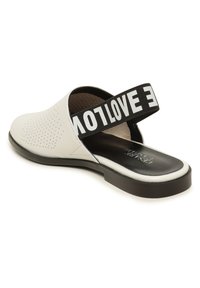 Chaussure en cuir blanc à enfiler avec un design perforé, bande élastique noire avec le texte "LOVE" en blanc, et une semelle plate noire.
