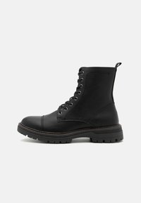 Botín de cuero negro hasta el tobillo con punta redonda, parte delantera con cordones, parte superior texturizada, tira para colocar y suela resistente con un dibujo pronunciado y costuras en contraste.