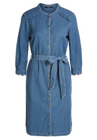 Denim-kjole med lange ermer, bølget halslinje, knappestolpe foran og bånd i midjen. Har en glatt tekstur og blå farge.