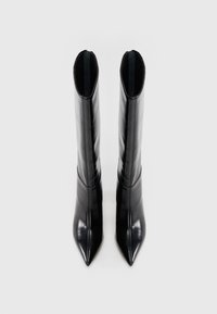 Botas de cuero negro hasta la mitad de la pantorrilla con punta afilada, textura suave y un diseño elegante, con un caña alta y sin herrajes visibles.
