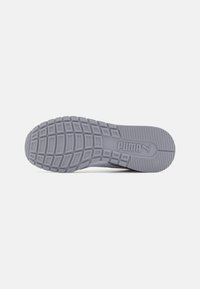 Semelle de sneaker en caoutchouc gris avec une surface texturée et motif comportant un logo distinct. Design plat et rectangulaire avec des rainures horizontales.