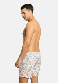 Bañadores para hombre con un patrón floral en tonos de rosa, azul y verde. Confeccionados en tela ligera, presentan una cinturilla elástica y un corte relajado.