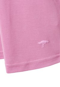 Roze katoenen T-shirt met een gladde textuur, voorzien van een klein geborduurd boomlogo dicht bij de zoom en gestikte randen.