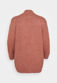 Knitted sweater in a warm terracotta color. Features a high neckline, dropped shoulders, and ribbed hem and sleeve cuffs. Textured fabric.