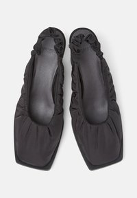 Scarpe nere flat con punta quadrata e tessuto arricciato attorno all'apertura, che mostrano un design elegante e moderno.