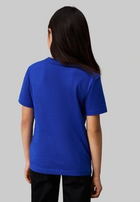T-shirt a maniche corte blu in un morbido cotone misto con scollatura rotonda. Design semplice, senza loghi o motivi visibili, con una vestibilità rilassata.