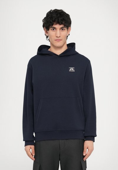 Sweat à capuche bleu marine avec une poche avant, des poignets côtelés et un petit logo imprimé sur la poitrine. Confectionné en tissu doux avec une coupe décontractée.
