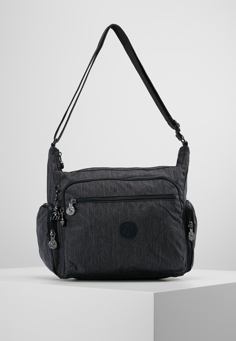 Gray fabric shoulder bag with multiple zippered compartments, adjustable strap, and circular logo on the front for added detail.