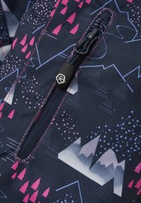 Marinfärgad tyg med geometriska mönster av berg och träd i rosa och vitt. Har en centrerad dragkedja med ett svart drag och rosa stickningar som accent.