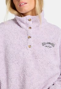 Lichtpaarse fleece pullover met een hoge kraag, vierknopssluiting bij de nek en geborduurd logo met golven en merknaam.