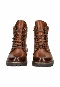 Par de botas de piel de cuero marrón pulida, con cordones, suelas de goma gruesa, ojales de metal y cremalleras laterales, mostradas de frente.