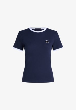 Temno modra rebrasta majica s kratkimi rokavi, z belim obrobljenim ovratnikom in rokavi. Ima majhen natisnjen logotip na prsih. Narejena je iz mehkega bombaža.