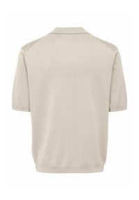 Polo en maille beige à manches courtes avec un col classique et un ourlet côtelé, présenté de dos sur un fond blanc.