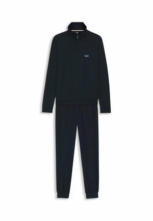 Navy tracksuit featuring zip-up jacket with stand collar and matching pants with elastic cuffs; made of soft fabric with subtle texture.