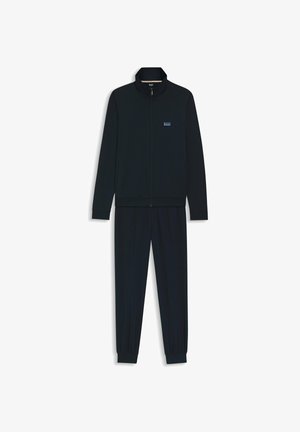 Navy tracksuit featuring zip-up jacket with stand collar and matching pants with elastic cuffs; made of soft fabric with subtle texture.
