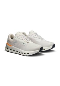 Lagana trkačka obuća u off-white boji s narančastim naglascima. Ima prozračnu gornju stranu, udoban potplat s kružnim izrezima i kontrastni crni potplat.
