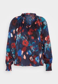 Blouse à manches longues avec encolure et poignets froncés, présentant un motif floral abstrait en bleu, rouge, noir et pêche.