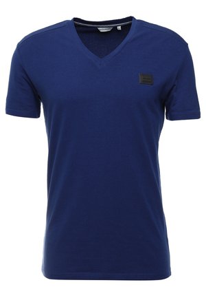 Marineblaue Baumwoll-T-Shirt mit V-Ausschnitt, kurzen Ärmeln und einem schwarzen rechteckigen Patch auf der Brust. Glatte Textur, lässiges Design.