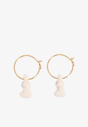 Pendientes de aro dorados con pequeños colgantes en forma de conejito blanco colgando dentro de cada aro.