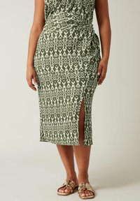 Abito midi verde e bianco con motivo ikat, dotato di una fessura laterale e dettaglio arricciato in vita. Tessuto morbido e strutturato.