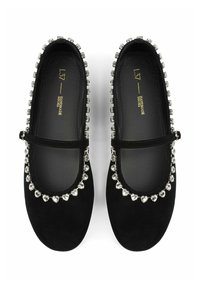 Bailarinas de ante negro con punta redonda, cinta estilo Mary Jane y una fila decorativa de piedras preciosas en forma de corazón, transparentes, a lo largo de la apertura.