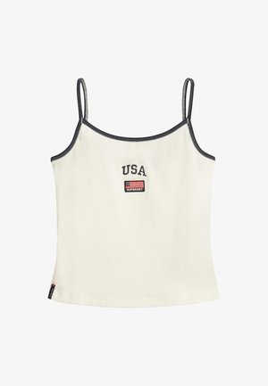 Hvid ribbet tanktop med tynde stropper. Har "USA" og en lille flagapplikation i marineblå. Kontrasterende marineblå sømme langs kanterne.