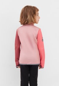 Kinderjacke in Pink und Koralle mit langen Ärmeln, schwarz-weißen gestreiften Bündchen und glatter Textur. Mit Logo auf dem linken Arm.