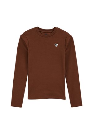 Haut à manches longues marron en tissu côtelé avec un design ajusté et une petite patch en forme de cœur sur la poitrine en marine et blanc.