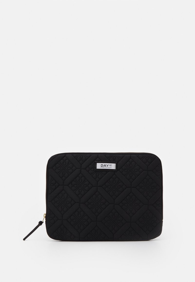 Trousse matelassée noire avec fermeture éclair, motif floral géométrique et une étiquette blanche portant la mention « DAY ET » au centre devant.