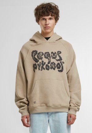 Beige bomulds hættetrøje med en sort fuzzy grafisk tekstdesign på forsiden, kængurulomme og ribbede manchetter og kant.