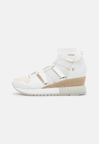 Zapatillas deportivas blancas con cuña, que presentan una combinación de malla y tejido sintético, correas elásticas, un detalle trenzado en el talón y suela de goma.