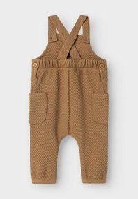 Salopette per neonati in tono marrone, con stoffa strutturata, spalline incrociate, vita elastica, bottoni laterali e tasche frontali, distesa su uno sfondo bianco.