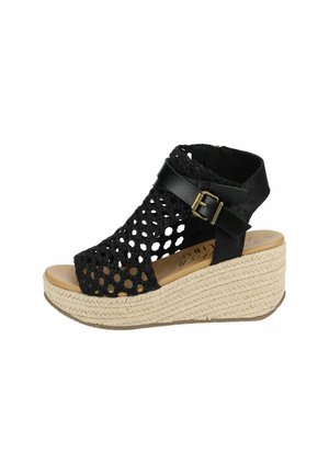 Black wedge sandal featuring a woven upper with a lattice design, adjustable ankle strap with buckle, and a textured rope sole.