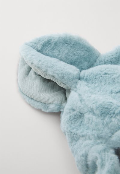 Puhány, világoskék plüss anyag, amely kerek formát öltött, puha fülekkel és kordbársonyos alsó réteggel rendelkezik. Zökkenőmentes, texturált felülettel bír.