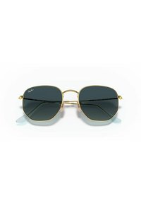 Gafas de sol Ray-Ban con un marco de metal dorado, lentes gris oscuro y forma hexagonal. Presentan puntas de temple transparentes y un diseño de doble puente.
