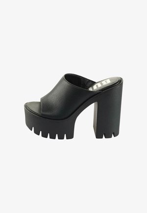 Mule plataforma negra con tacón grueso y robusto, punta abierta, parte superior texturizada y surcos profundos en la suela y el tacón para mayor agarre.
