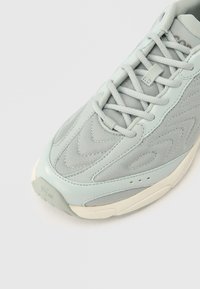 Ανοιχτό μπλε αθλητικό παπούτσ ι με επάνω μέρος από δίχτυ με υφή, επενδεδυμένη γλώσσα και λαστιχένια σόλα. Σύστημα κορδονιών με ενισχυμένες λεπτομέρειες.