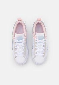 Vita idrottsskor i vitt med grå, rosa och blå accenter, med en texturerad ovandel, rund tå och kontrasterande snören.