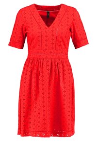 Robe rouge à manches courtes, décolleté en V, motifs découpés décoratifs et taille froncée. Tissu léger, style jusqu'aux genoux.