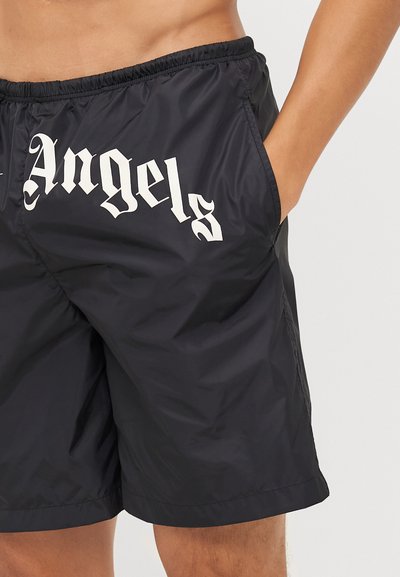 Melni peldēšanas šorti ar elastīgu jostu, ar sānu kabatu un lielu baltu tekstu "Angels" priekšpusē. Viegls, gluds audums.