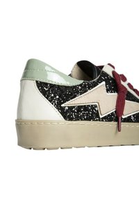 Zapatillas con parte superior de purpurina negra, acentos en blanco y verde claro, suela beige y cordones burdeos. Presentan un diseño de rayo.