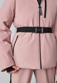 Ūdensizturīgs rozā jaka ar pieguļošu dizainu, kas papildināta ar melniem akcentiem, logotipa jostu un rāvējslēdzēju kabatām funkcionalitātes nodrošināšanai.