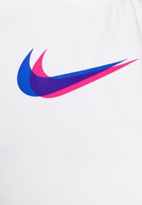 Na białym tle tkaniny nachodzące na siebie logo Nike w formie znaku Swoosh w kolorach niebieskim, fioletowym i różowym.