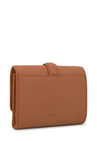 Cartera de cuero marrón con textura suave, diseño plegable y la marca "TOUS" en relieve en la parte frontal. Presenta detalles de costuras prolijas.