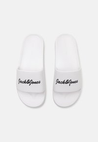Baltos šlepetės su tekstūruotu pado paviršiumi, plokščiu padu ir plačia juosta, kurioje juodu kursyvu užrašyta "Jack&Jones".