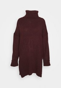 Maglione oversize color bordeaux con collo alto a dolcevita, polsini a costine e spacco laterale. Realizzato in morbido materiale a maglia. Presenta un dettaglio con cucitura centrale.