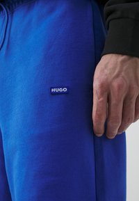 HUGO NASENSIO - Donji dijelovi trenirke - open blue