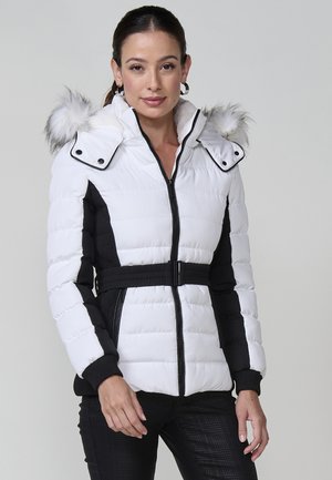 Chaqueta acolchada en blanco y negro, con capucha de piel sintética, cierre de cremallera y cintura ajustada. Acabados texturizados en negro a lo largo de las mangas.