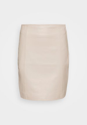 Jupe droite beige longueur genou avec des coutures verticales, en tissu lisse, présentée sur fond blanc uni.