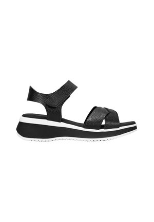 Sandalias de piel negra con tiras cruzadas, plantilla acolchada y suela gruesa en blanco y negro. Cuenta con una correa en el tobillo que las sujeta de forma segura.